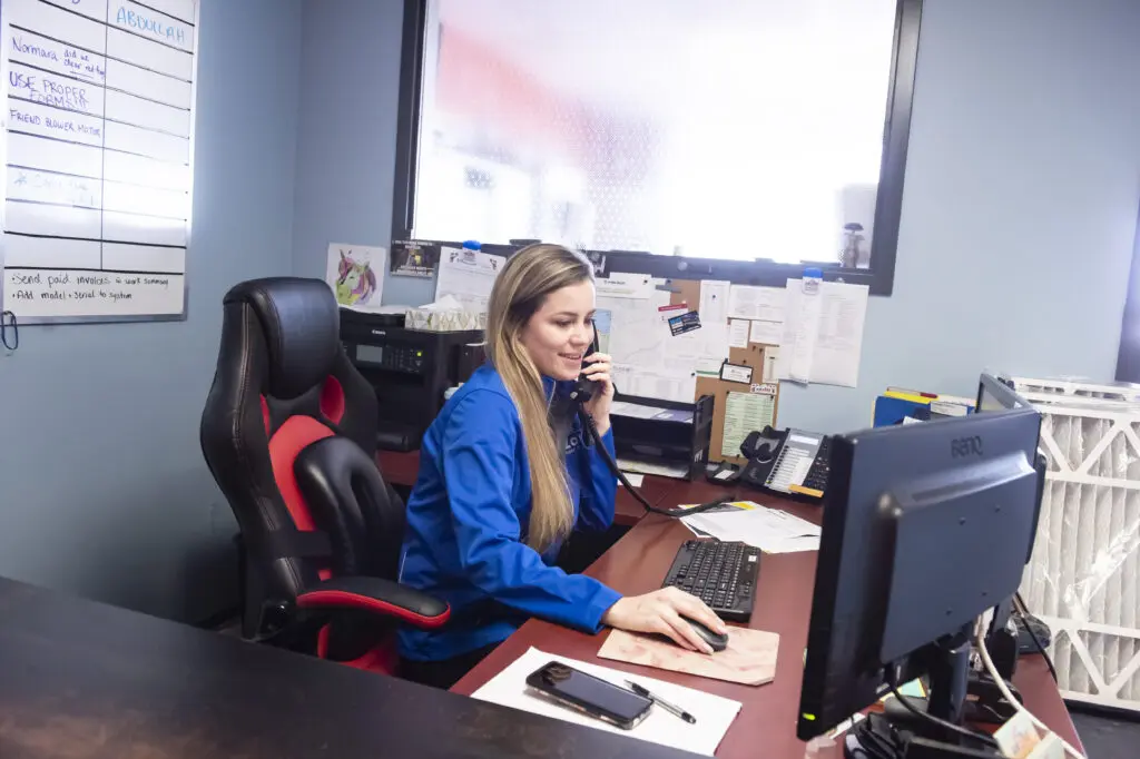 An AirZone team member speaking with a customer by phone at the office
