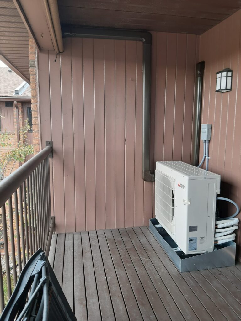 Mitsubishi ductless outdoor unit beside a deck railing