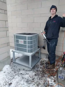Felix HVAC Maintenance and Service Technician in Ottawa - AirZone HVAC Services - AirZone HVAC Services Felix from AirZone beside a Bosch heat pump during HVAC service work in Ottawa