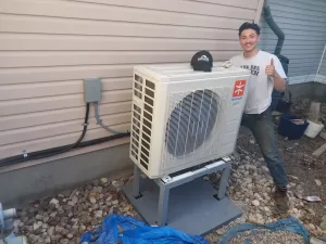 A proud technician completing a heat pump installation in Ottawa. AirZone HVAC Services provides complete cold climate heat pump services.