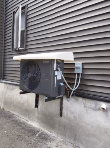 Central Moov with cover - AirZone HVAC Services - AirZone HVAC Services Central Moov cold climate heat pump installation on a Ottawa home with siding mounded on brackets with a heat pump cover.
