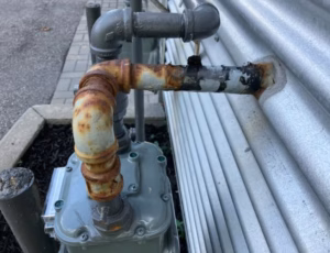 Enbridge Gas Meter Replacement in Ottawa - AirZone HVAC Services - AirZone HVAC Services Weathered exterior gas piping connected to a residential gas meter in Ottawa